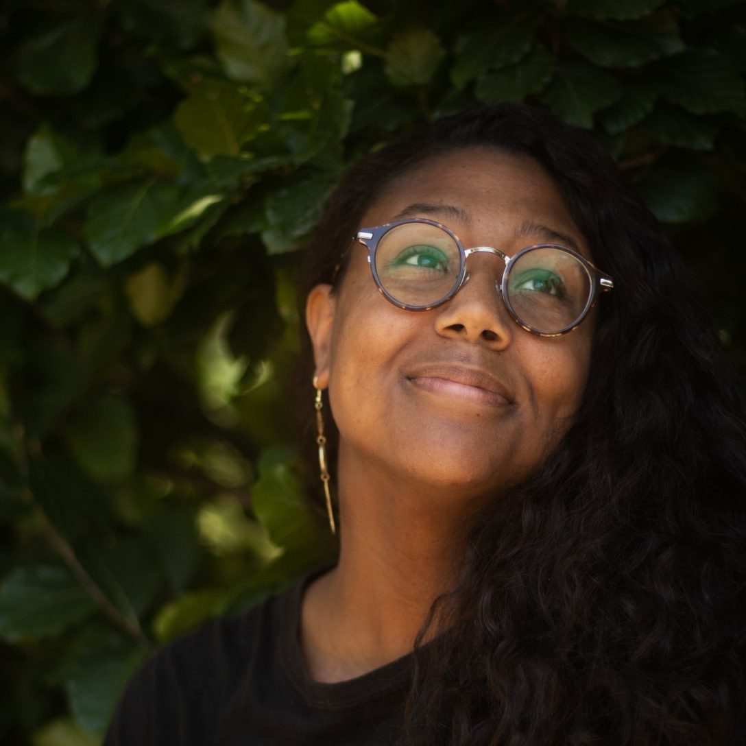 Desirée looks up and to the right with a slight smile.